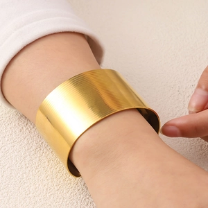 Elegant wide textured gold bangle with irregular vintage design on model wrist
