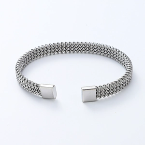 Macro detail of silver mesh woven stainless steel open cuff bracelet with polished ends