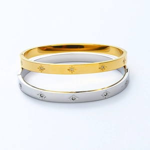 Detailed close-up of gold and silver stainless steel bangles with star-shaped engravings