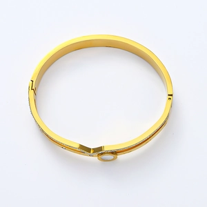 Détail du bracelet double couche plaqué or avec encoche en V et incrustation blanche