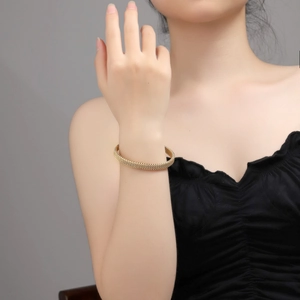 Detail of 18K gold plated mesh woven cuff bracelet on wrist showing fine texture