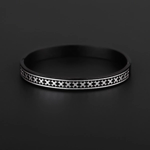 Macro detail of matte black titanium steel bracelet with silver engraved star patterns