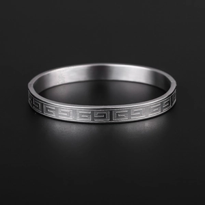 Polished silver titanium steel ring with retro Greek key pattern on black background