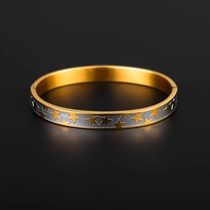 Détail du bracelet rigide en acier doré 18K avec motifs d'étoiles gravés et charnière