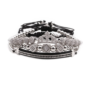 Nahaufnahme von silbernen und schwarzen Kronenarmbändern mit Zirkonia und Kordeln