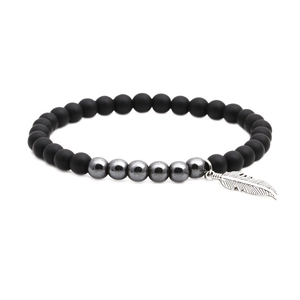 Bracelet en perles d'onyx mat et hématite avec un pendentif plume en argent détaillé