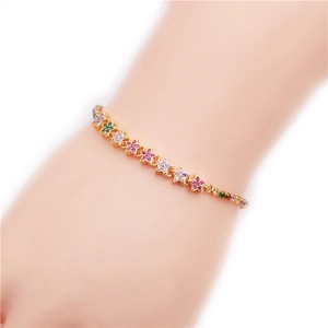 Détail du bracelet chaîne étoile doré avec zircons colorés sur le poignet féminin