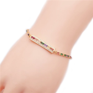 Bracelet doré avec zircons rectangulaires colorés et accents arc-en-ciel sur le poignet