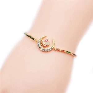 Détail d'un bracelet doré ajustable avec croissant de lune et zircons arc-en-ciel