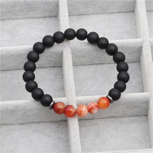 Détail des perles de 8mm en pierre noire mate et agate rayée sur un bracelet perlé