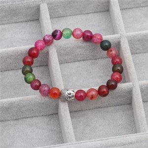 Detailed macro view of multicolor dragon vein agate beads with a silver buddha head charm