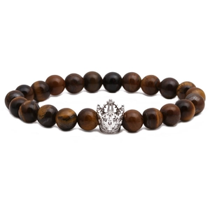 Bracciale di perle occhio di tigre con ciondolo a corona d'argento su sfondo bianco