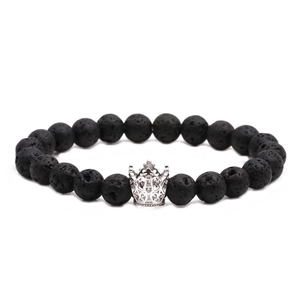 Bracciale in perline di pietra lavica con ciondolo a corona d'argento su sfondo bianco