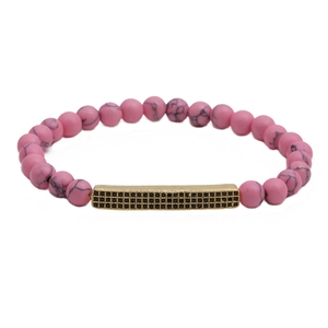 Gros plan sur les perles en pierre rose de 6mm et barre dorée avec pavé noir