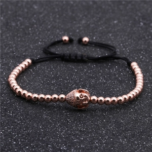 Dettaglio del bracciale con perline oro rosa, ciondolo Buddha e cordino regolabile