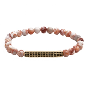 Détail d'un bracelet en perles de pierre sésame rouge avec barre dorée et micro-pavage noir