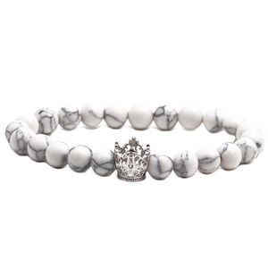 Dettaglio del bracciale con perline di turchese bianco e ciondolo a corona d'argento