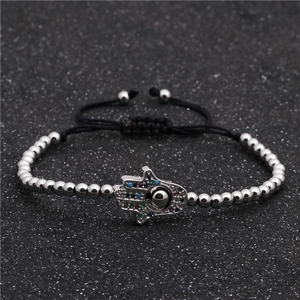 Detalle de la mano de Fátima con circonitas de colores en pulsera de cuentas plateadas