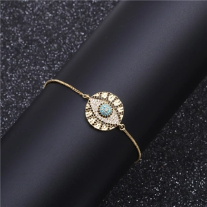 Macro shot of gold Evil Eye bracelet with blue turquoise and pavé cubic zirconia