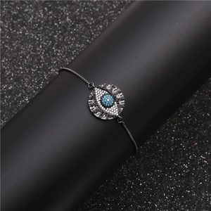 Adjustable evil eye bracelet with blue zircon and black chain on a dark display