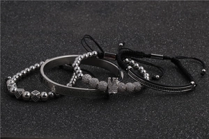 Detail von Silberkronen-Armbändern mit römischen Ziffern und Zirkonia auf dunklem Sand