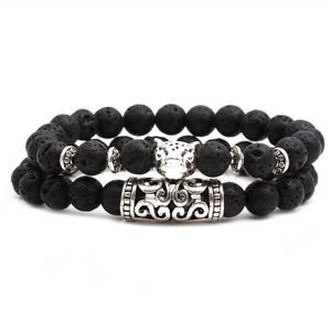 Gros plan d'un bracelet en pierre de lave avec tête de léopard en argent et tube ciselé