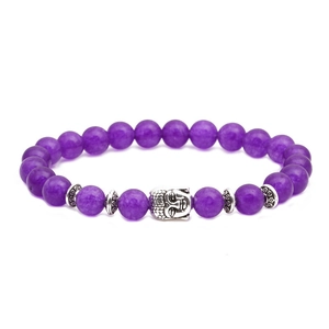 Vue macro de perles d'améthyste violettes et d'une breloque tête de Bouddha en argent vieilli