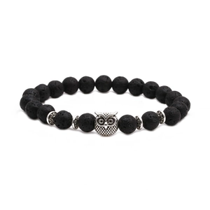Détail des perles en pierre de lave naturelle et pendentif hibou argenté sur le bracelet