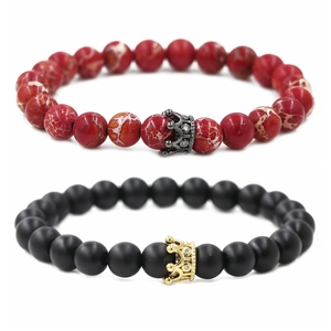 Detail of beaded bracelets with red marble, matte black stones and zircon crown charms