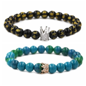 Detail view of black and turquoise beaded crown bracelets with gold character engravings