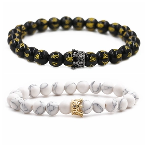 Detailed close-up of 8mm black mantra beads and white marble stone crown bracelets