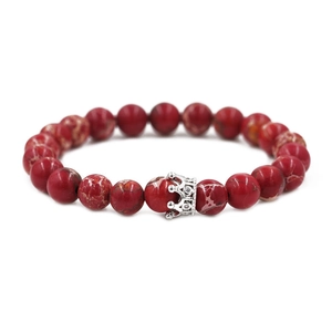 Makroaufnahme des roten Jaspis-Perlenarmbands mit silbernem Kronenanhänger und Zirkonia
