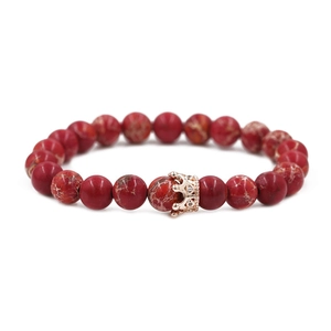 Detail von 8mm roten Kaiserstein-Perlen und roségoldener Krone auf dem Perlenarmband