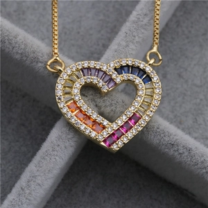 Détail macro du collier coeur doré avec pierres arc-en-ciel et pavage de zircons blancs