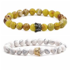 Detail of 8mm natural stone bracelets featuring gold and black micro-paved crown beads