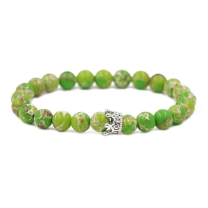 Nahaufnahme von 8mm grünen Kaiserstein Perlen mit einem silbernen Kronenanhänger Armband