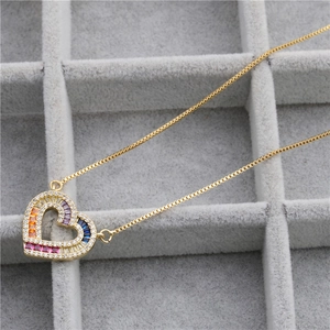 Collier pendentif cœur doré élégant avec zircone arc-en-ciel dans un écrin à bijoux