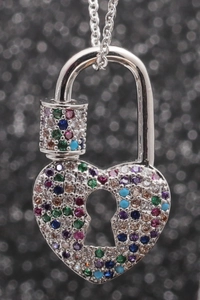 Collier cadenas cœur en argent serti de zircons multicolores sur fond bokeh noir élégant