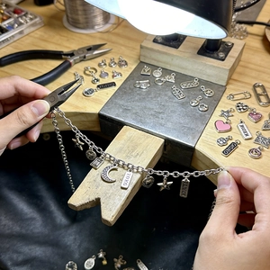 12Pcs silver chain bracelet set with moon and star charms on a wooden DIY craft table