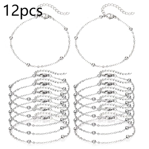 Détail macro de 12 bracelets chaîne à billes argentés avec fermoirs homard et extensions
