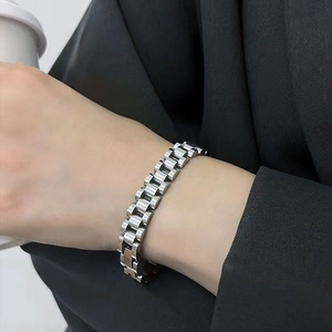 Bracelet à maillons en acier inoxydable argenté poli porté au poignet pour un look moderne