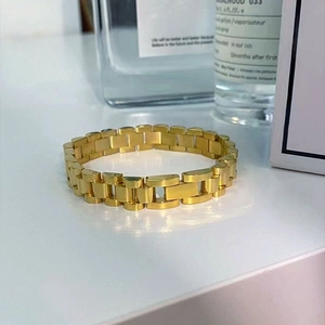 Détail d'un bracelet de style montre présidentielle en acier inoxydable doré sur fond blanc