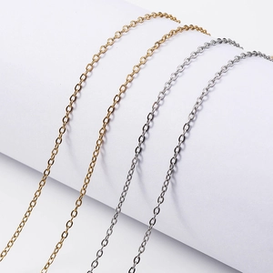 1.5mm stainless steel cable chain necklaces in gold and silver finishes on a white pedestal