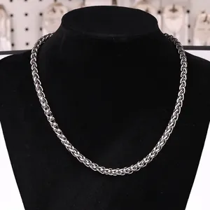 Detail of silver stainless steel wheat chain necklace displayed on a black bust stand