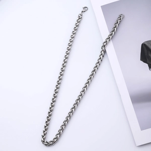 Detail of silver stainless steel wheat chain showing lobster clasp and woven texture