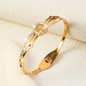 Close-up of golden stainless steel tree of life bangle showing engraved S.steel logo