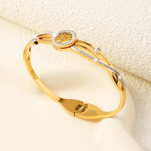 Macro detail of gold tree of life bangle with crystal insets and polished steel finish