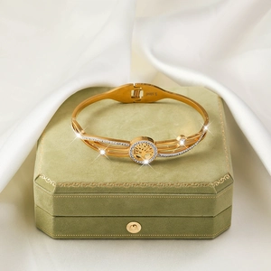 Gold stainless steel tree of life bangle with sparkling zircons on green velvet box