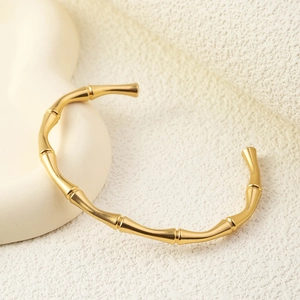 Detailed close-up of champagne gold bamboo style cuff bracelet with natural joint texture