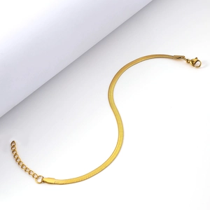 Close-up of golden flat snake chain bracelet with polished lobster clasp and extension link